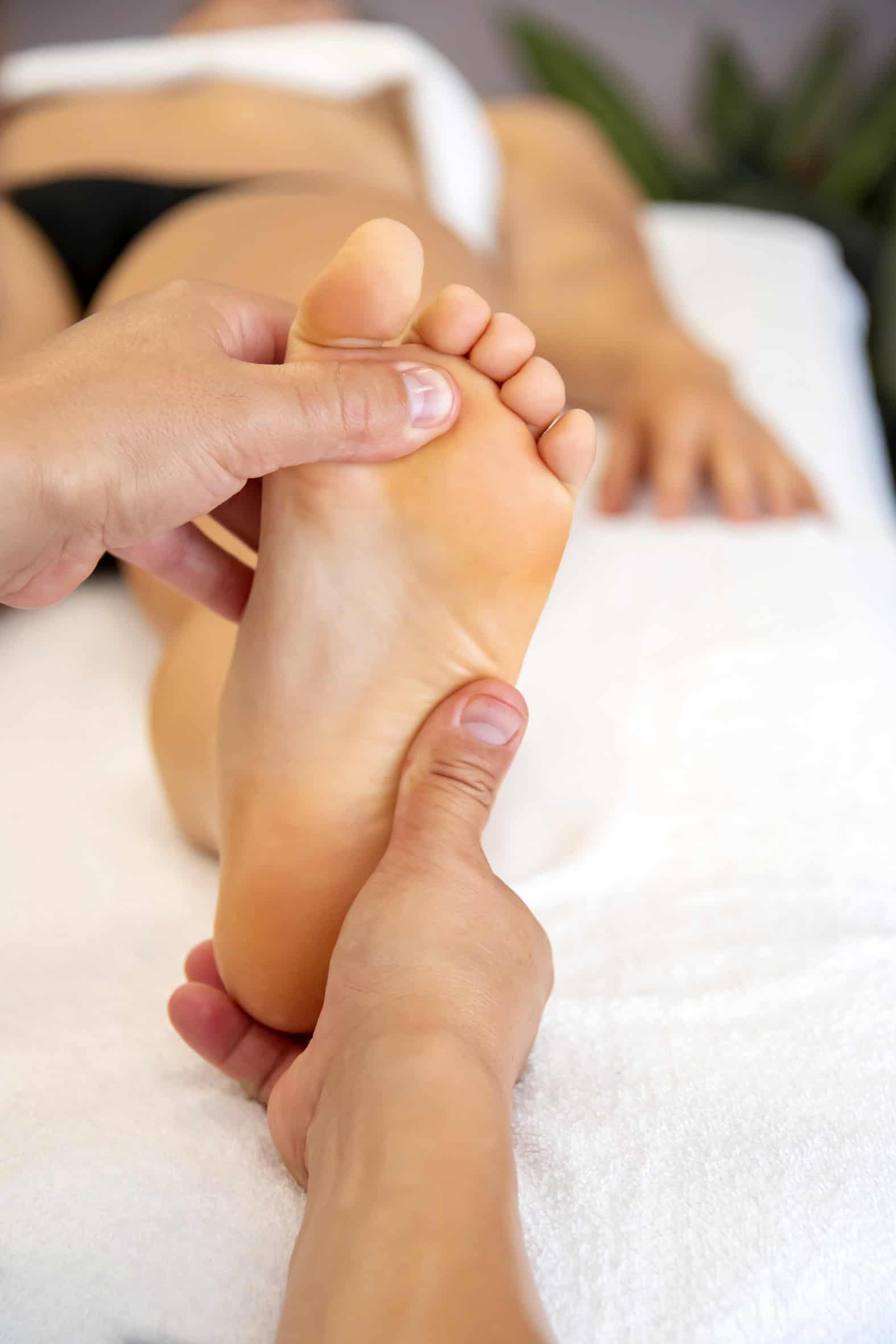 Massaggiatore che lavora sui piedi durante una sessione di benessere.