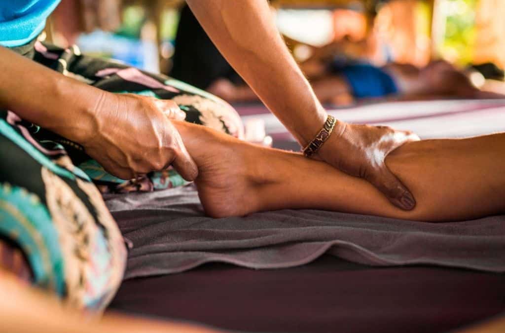 Massaggiatore che effettua un massaggio sportivo su una persona, promuovendo benessere e relax.