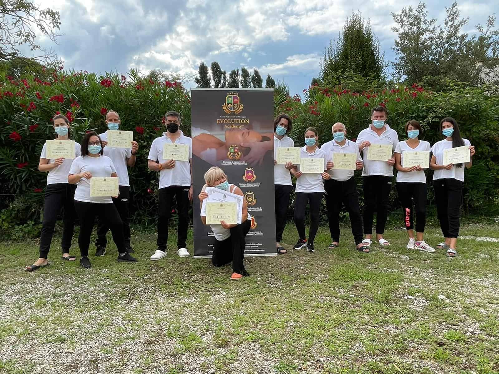 Diplomati di Evolution Academy® con certificati di formazione in benessere e crescita personale in un contesto all'aperto.