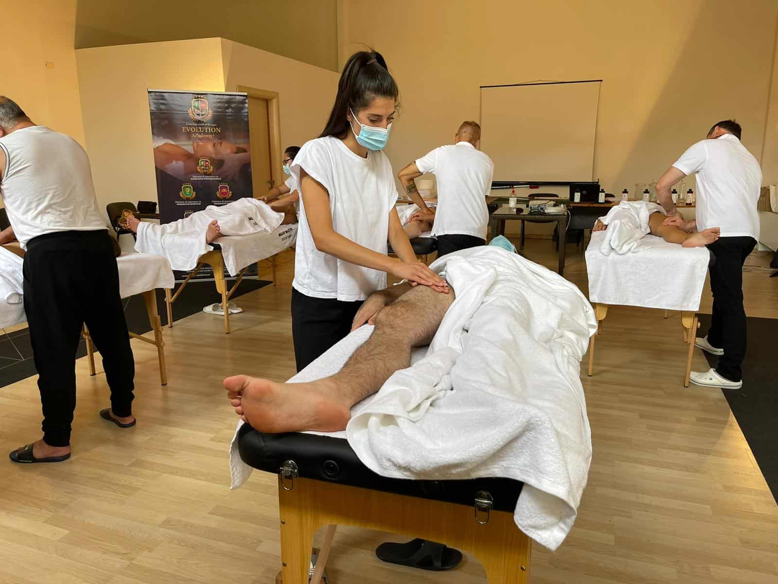 Massaggiatori che praticano tecniche di terapia del massaggio su clienti in un ambiente formativo.