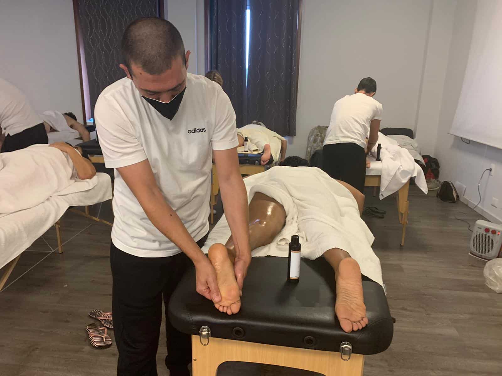 Massaggiatore che lavora su un cliente durante corso di formazione presso Evolution Academy®.