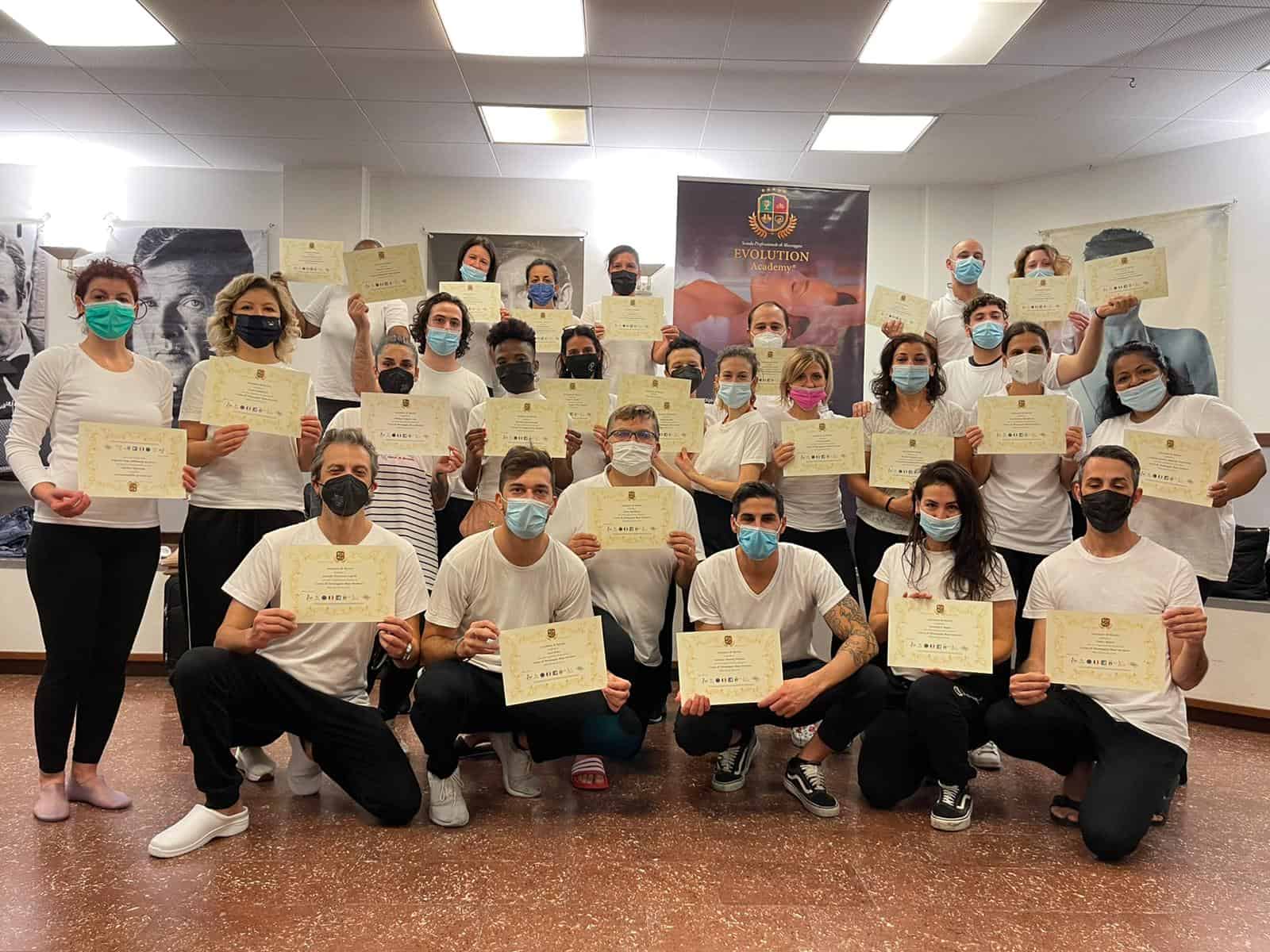 Corso di formazione Evolution Academy® con diplomati sorridenti e mascherine, atmosfera professionale e motivante.