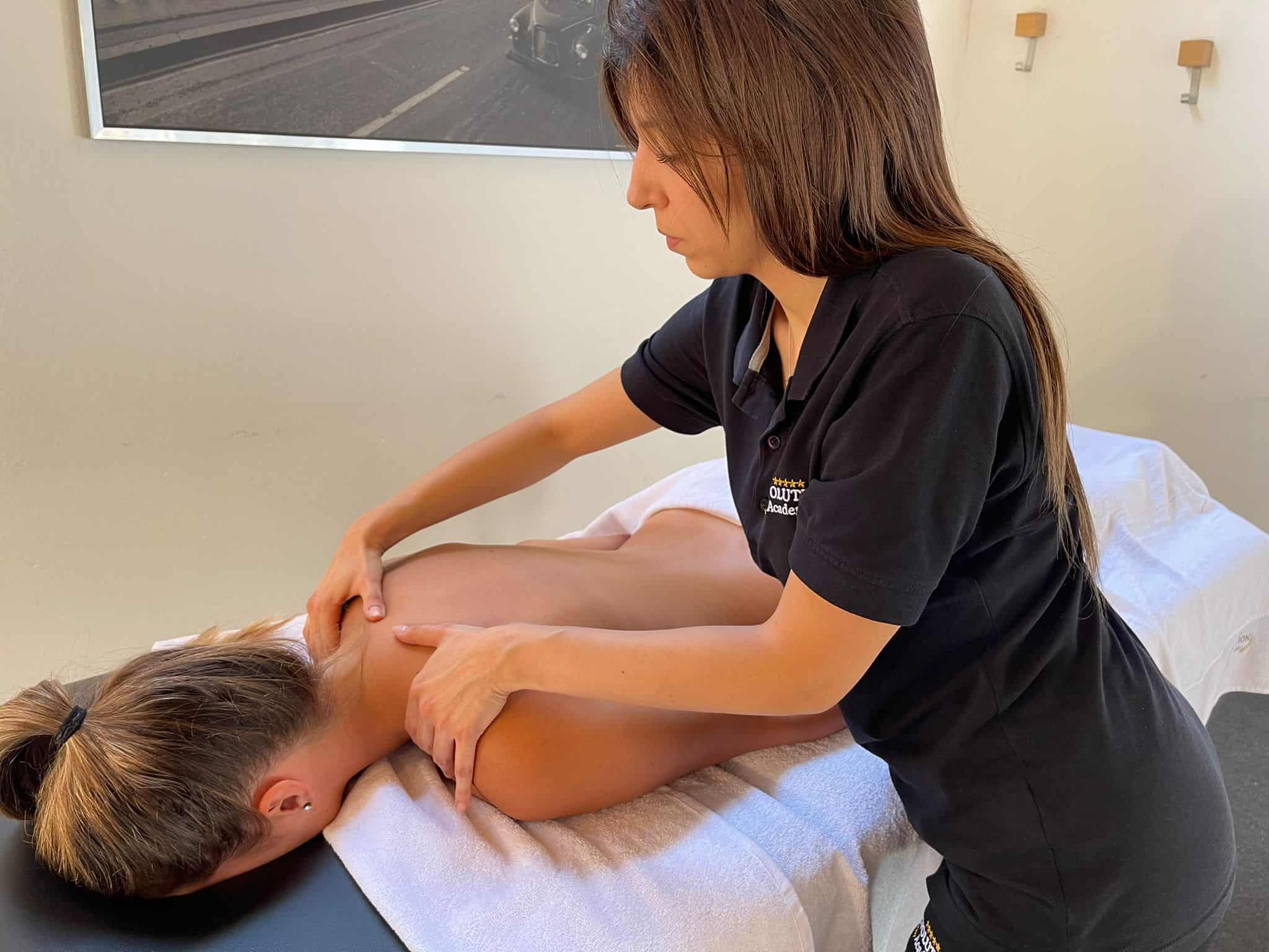 Massaggiatrice professionale durante trattamento di riabilitazione muscolare - Evolution Academy®.