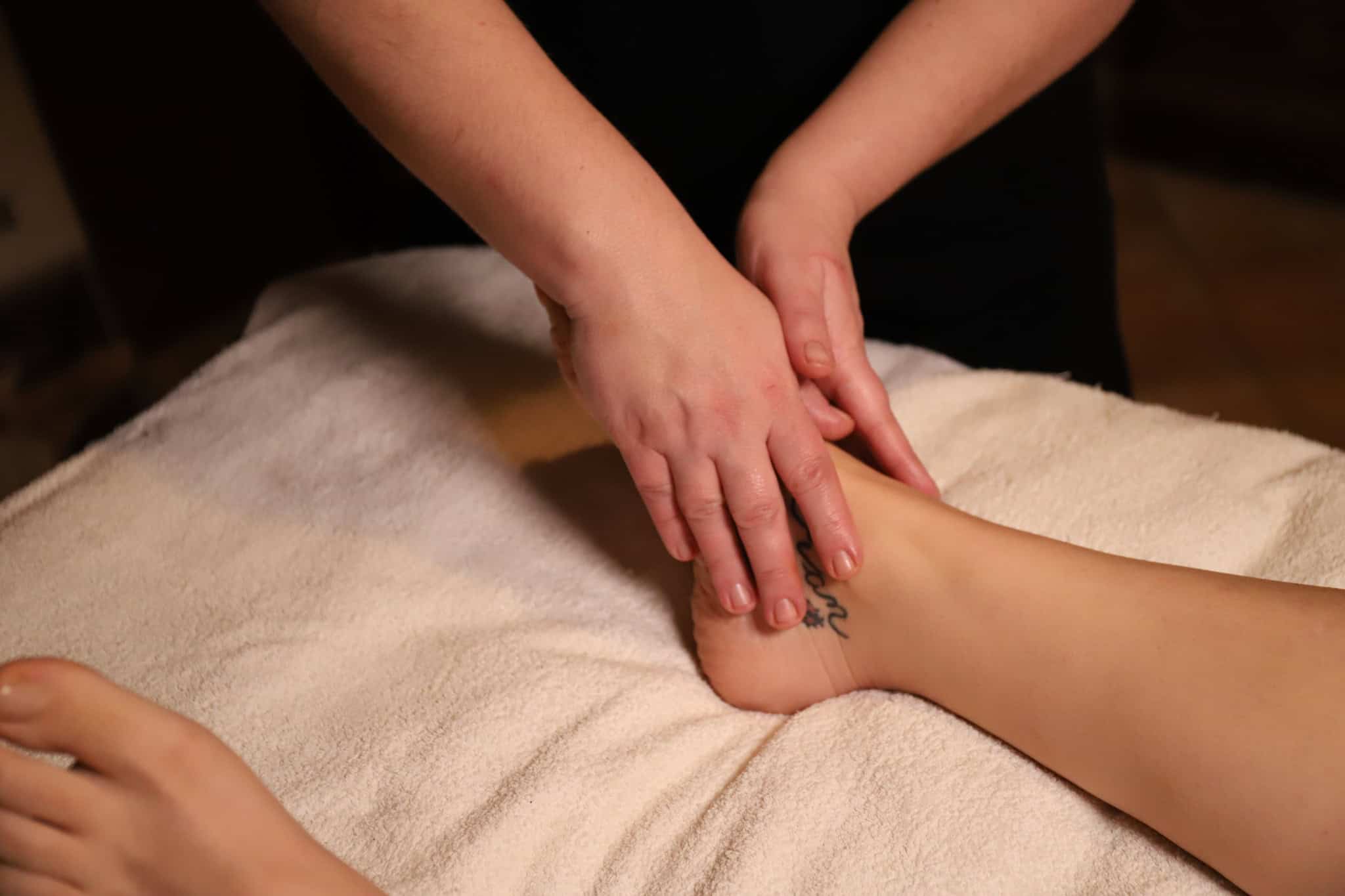 Riflessologia plantare durante sessione di benessere e terapia naturale.