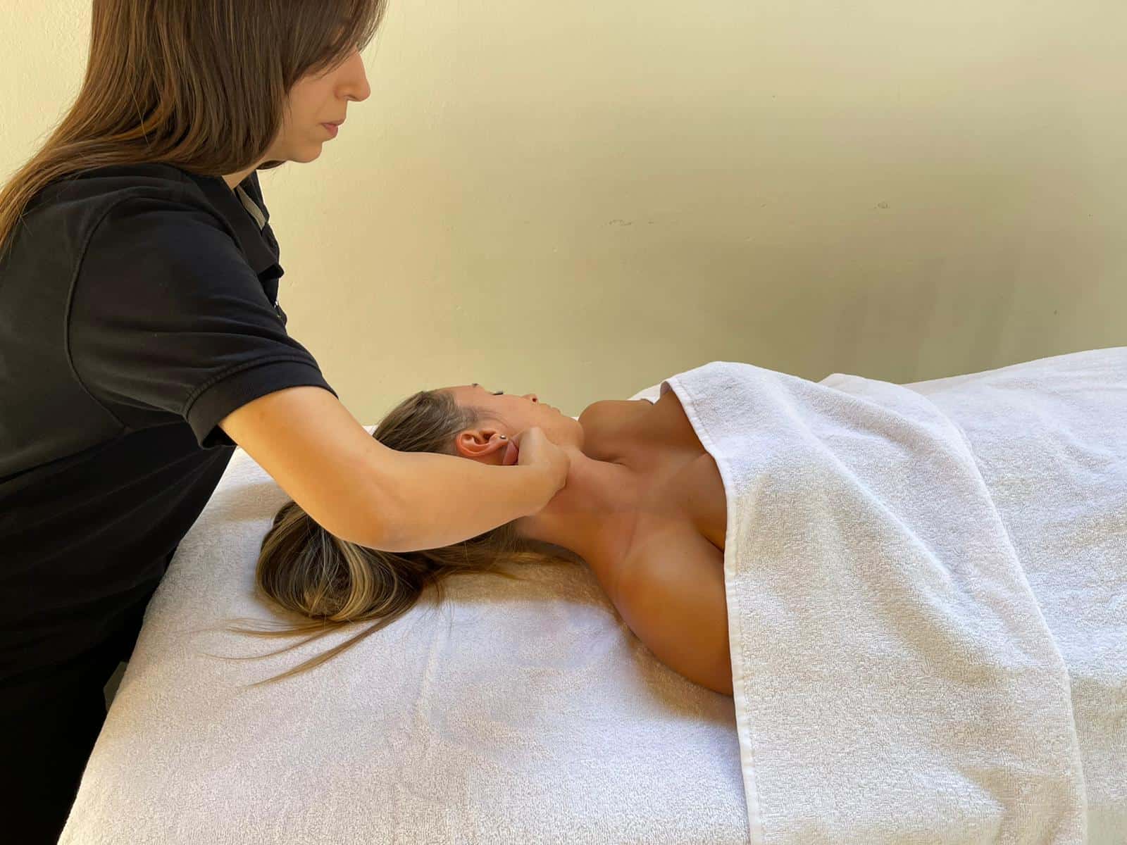 Tecnica di massaggio terapeutico al collo in ambiente professionale.