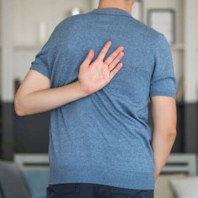 Dolore al petto, persona che si tiene la schiena, problema di salute, consulenza medica, Evolution Academy®.