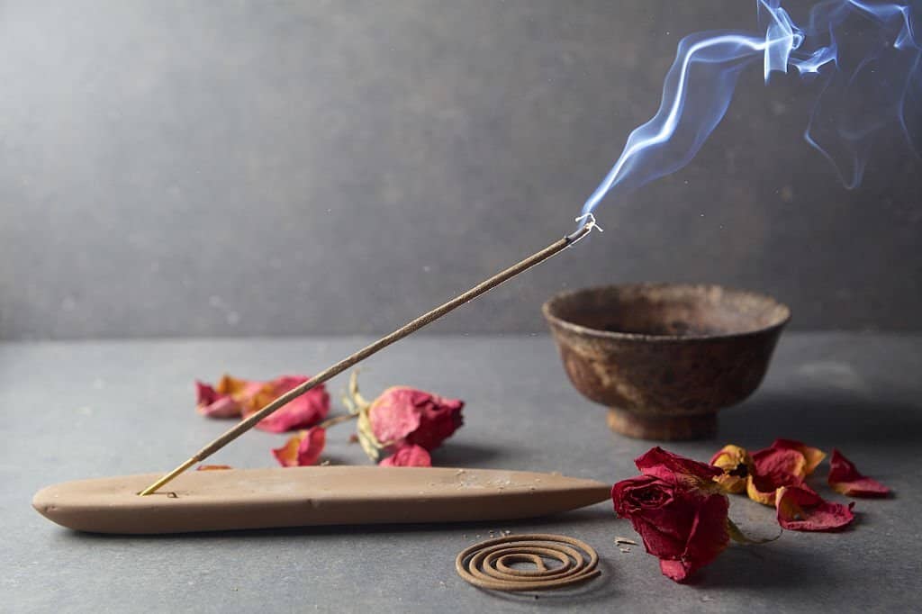 Fuoco d'incenso e petali di rosa secchi, simbolo di crescita personale e spirituale.