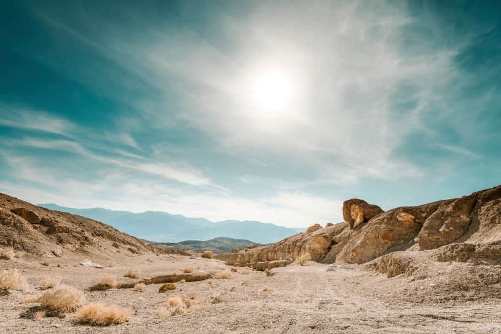 Sabbia desertica con formazioni rocciose e cielo soleggiato, ambiente di formazione personale e crescita interiore.