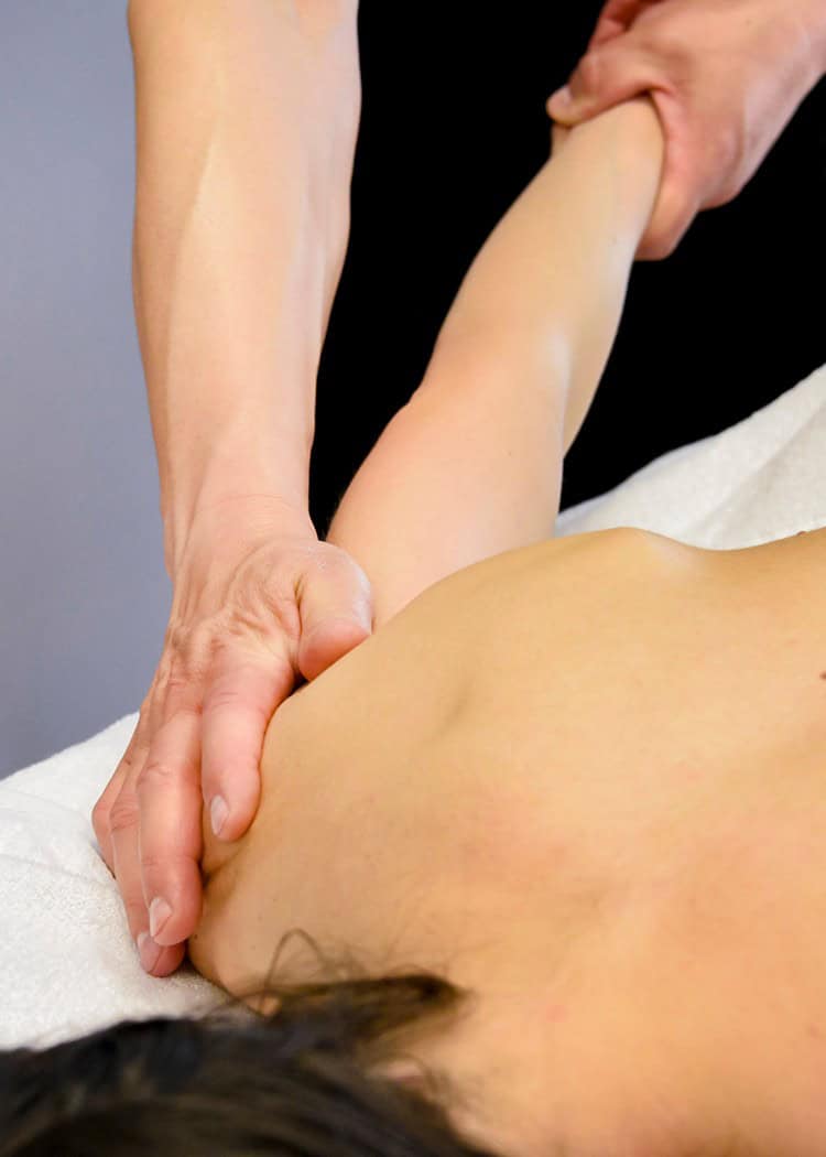 Massaggiatore che esegue terapia fisica su schiena di donna in un centro benessere.